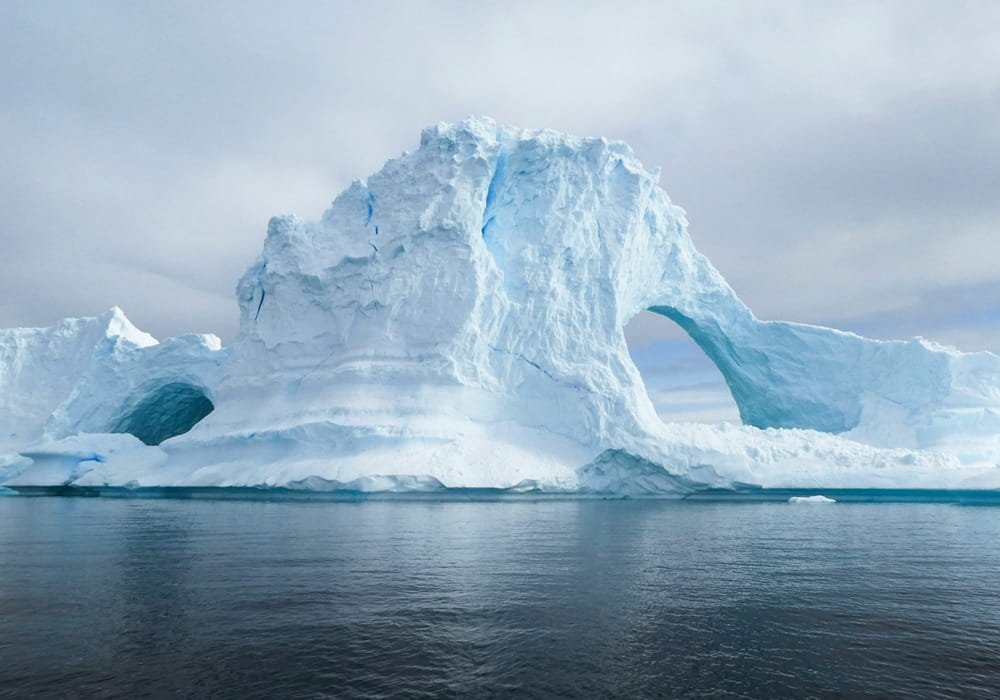 Antarctic Iceberg Arch in the Frozen Antarctic Desert Ocean